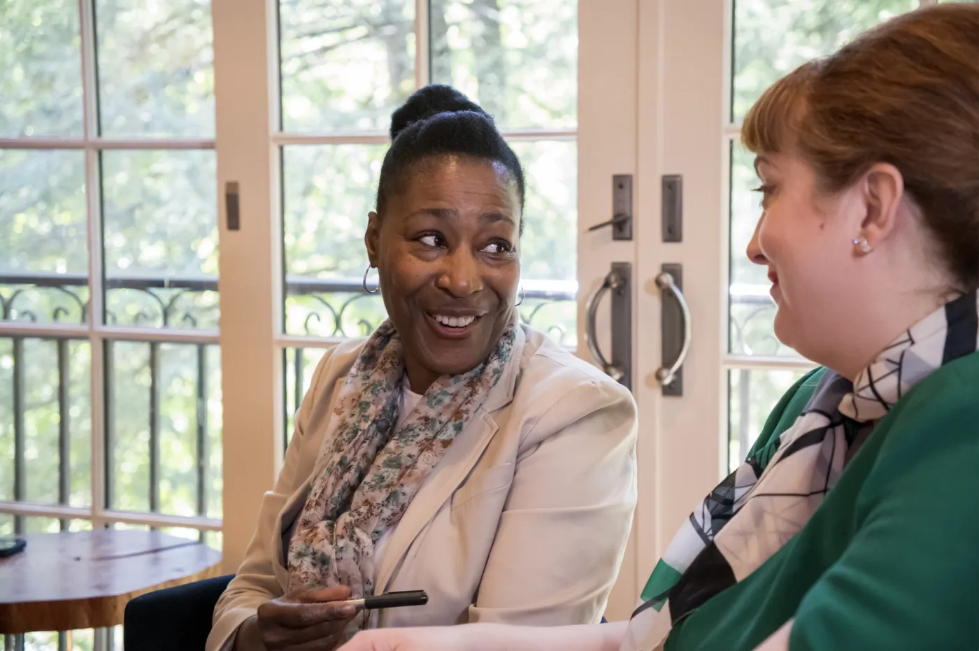 Two women in conversation at a table.